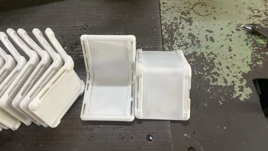 Early injection-molded parts of the fitness cuff shell in white
