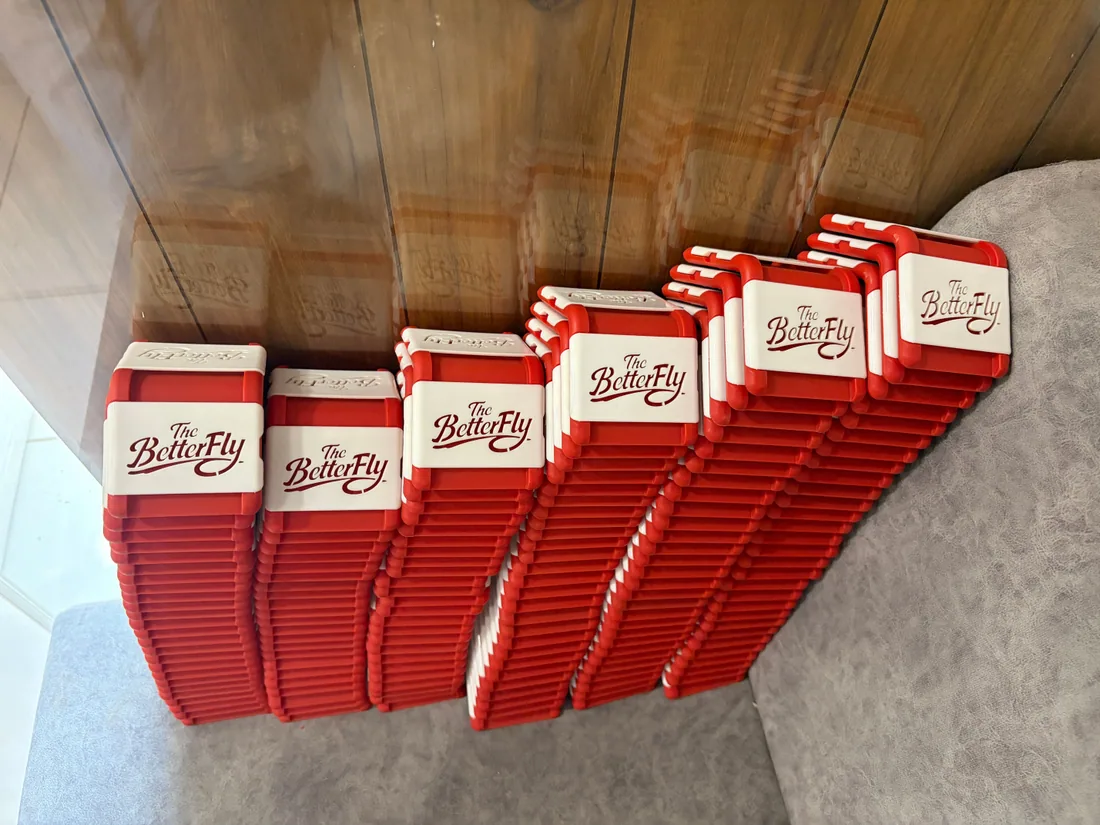 Rows of assembled red fitness cuffs with branded inserts, ready to pack