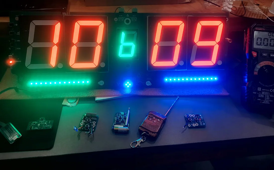 Pickleball scoreboard prototype lit on the test bench with its remote and control boards laid out in front