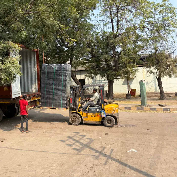 A forklift moving a packed shipment near a loading truck