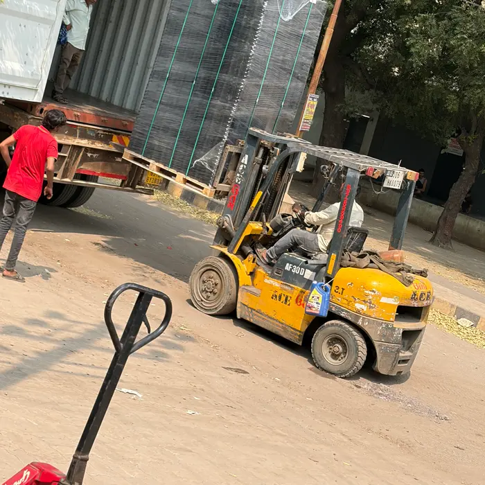 A forklift lifting a wrapped shipment for loading