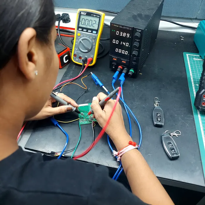 An engineer testing a circuit board with a multimeter and bench power supply