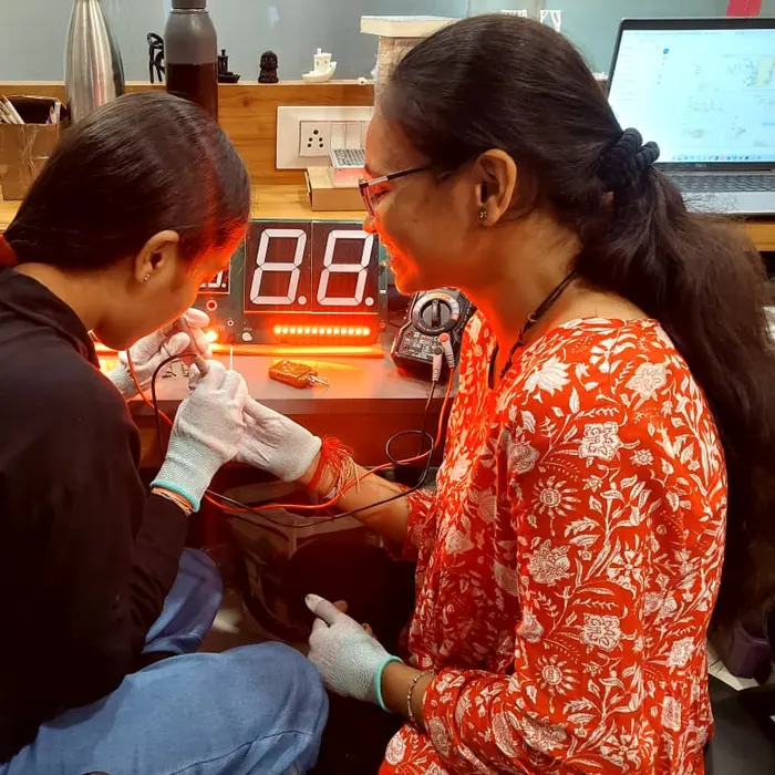 Two engineers soldering and debugging an embedded electronics prototype