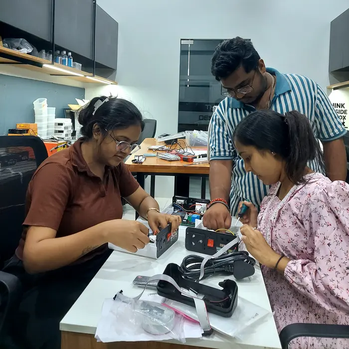 Engineers debugging a hardware prototype together at the workbench