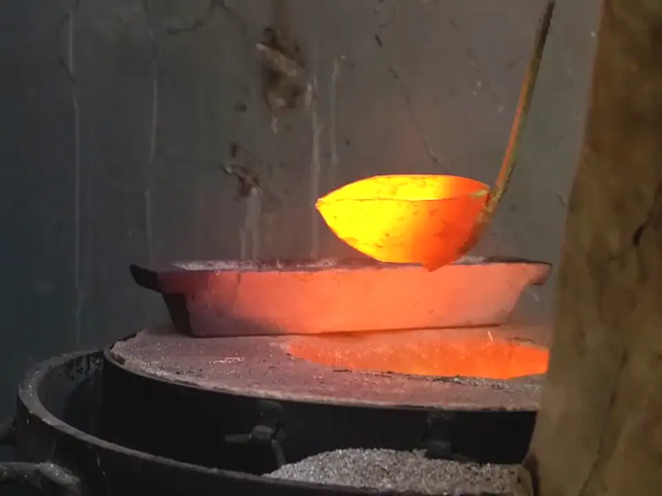 Molten metal poured from a ladle into a clamped casting mold