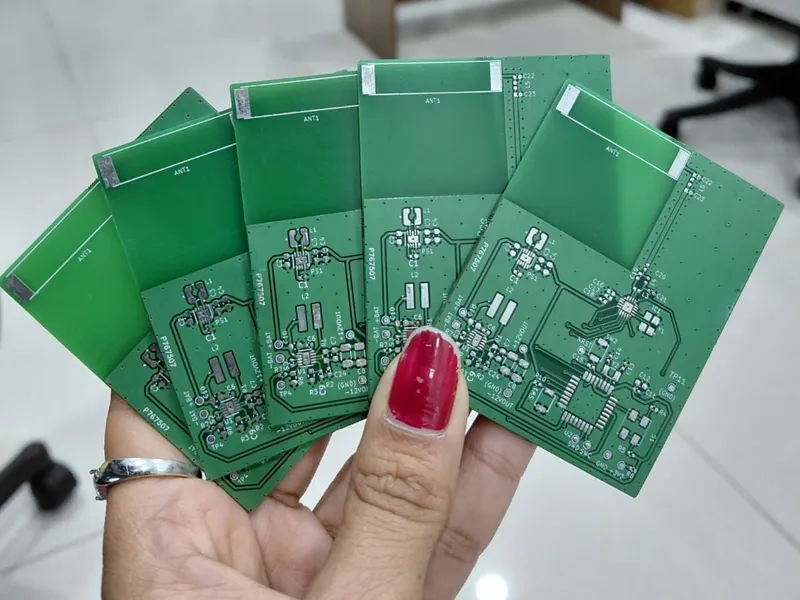 Five bare PCBs for the smart film RF controller fanned out in one hand