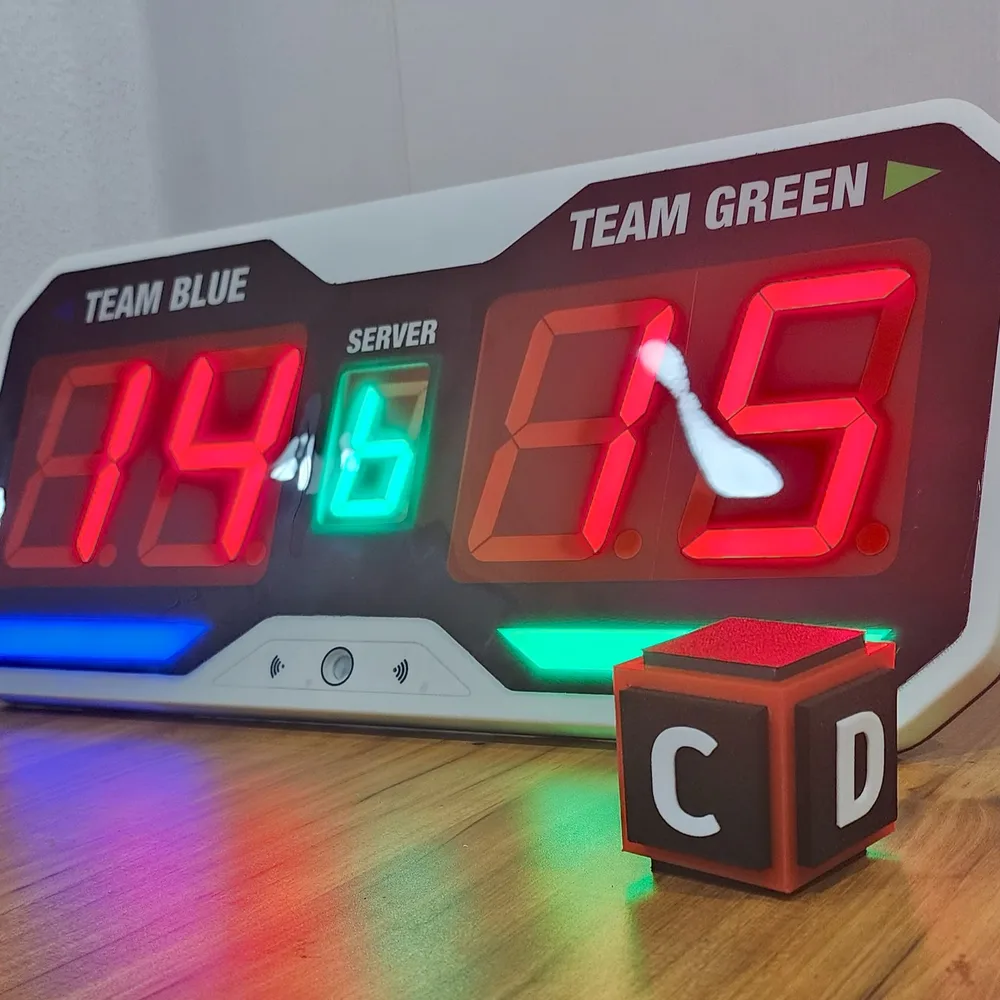 Close-up of the redesigned pickleball scoring unit displaying a live score next to its wearable controller